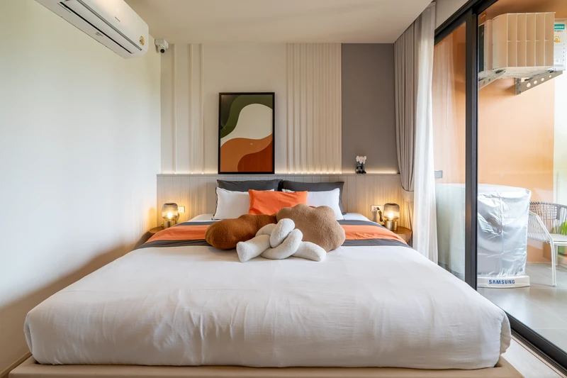 Saint Tropez Naithon — studio A show unit, 30.62 m²: the bed by the full-height window onto greenery