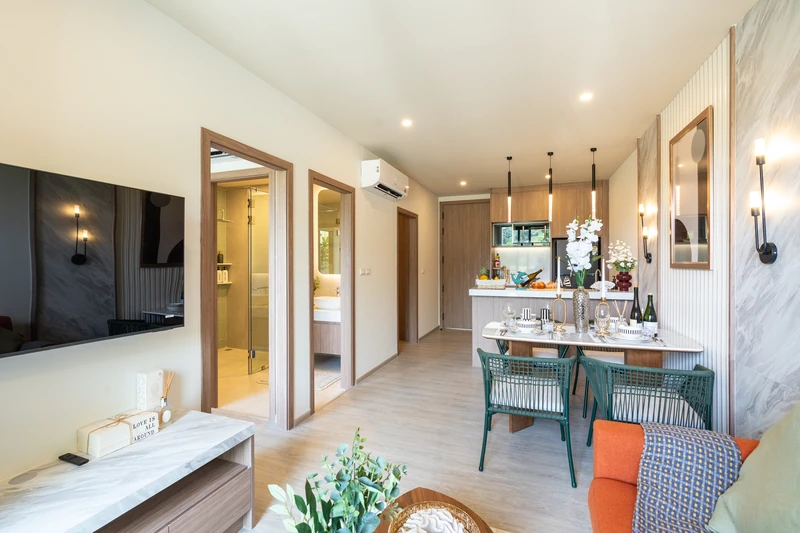 Saint Tropez Naithon — two-bedroom B1 show unit: living room with TV, doors to the bedroom and bathroom