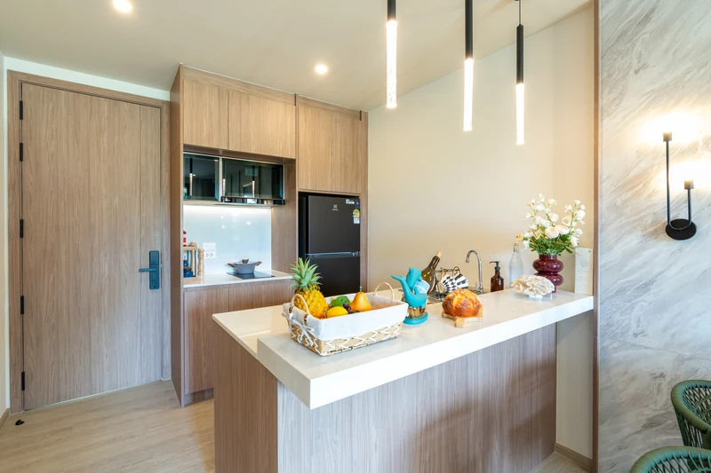 Saint Tropez Naithon — two-bedroom B1 show unit: kitchen by the entrance with fridge and built-in appliances